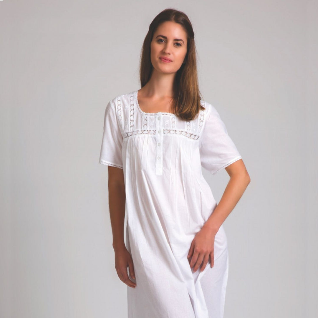Model wearing white cotton short sleeve nightie with buttoned bodice and embroidery