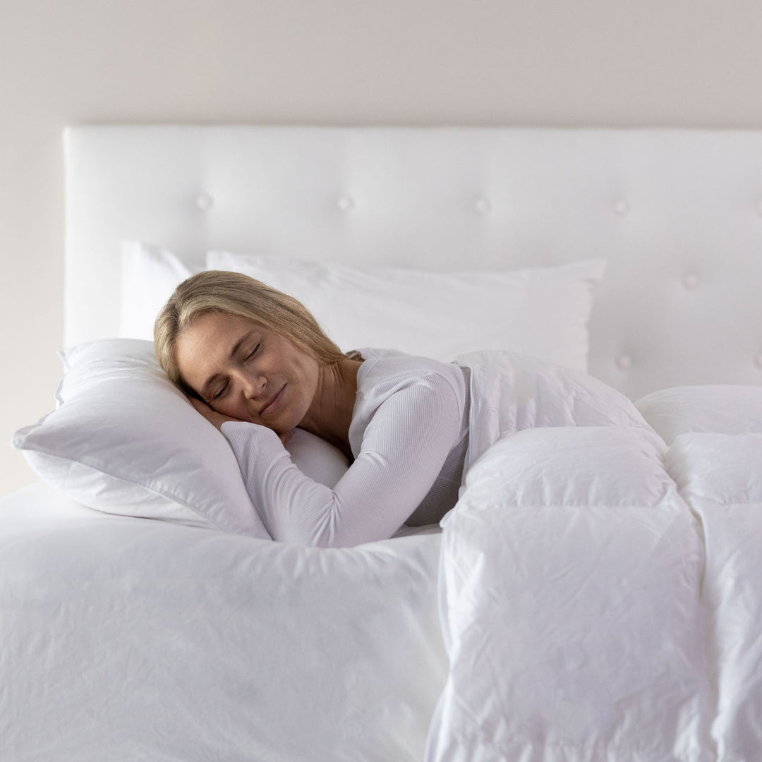 A person is lying on a white pillow in bed, which appears soft and comfortable.