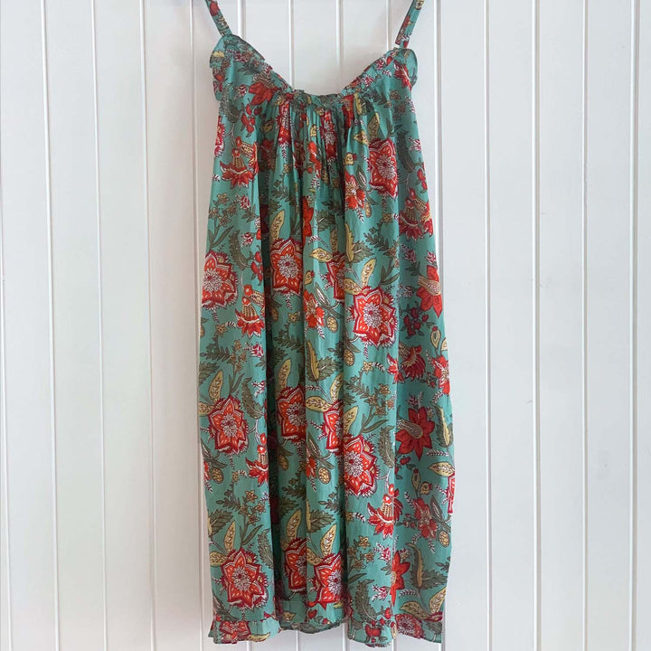 Back view of Belinda teal blue nightie hanging on wall, featuring red floral cotton print and lightweight summer fabric