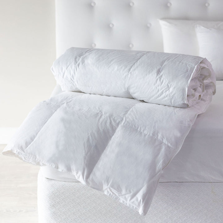 Royale Danish Eiderdown quilt neatly rolled on a bed, showcasing premium goose down fill and luxury cotton casing.
