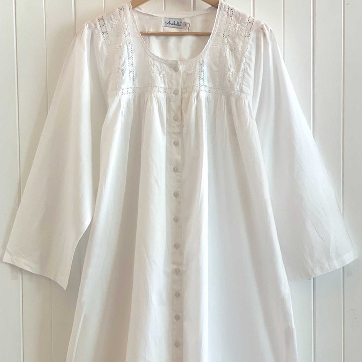 Lily nightie hanging on a wooden hanger, showing embroidered bodice and button-down front.