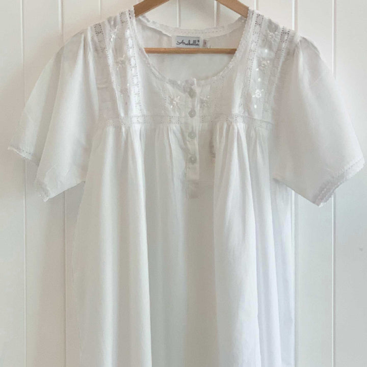 White cotton short sleeve nightie with lace trim on hanger