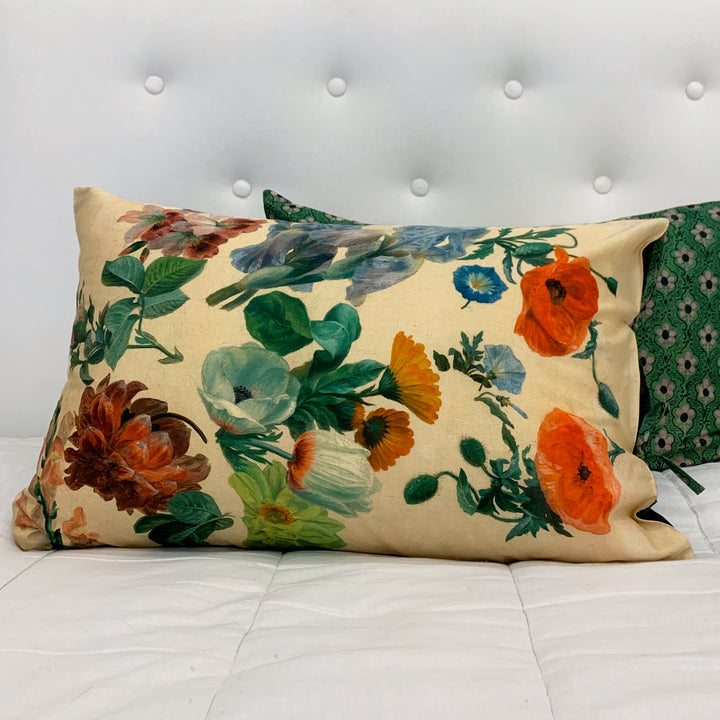 Floral-patterned pillow on a bed with a white headboard