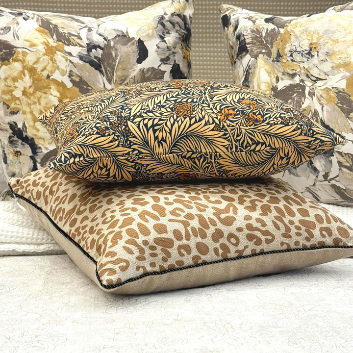 Decorative pillows with floral and leopard print patterns on a neutral background