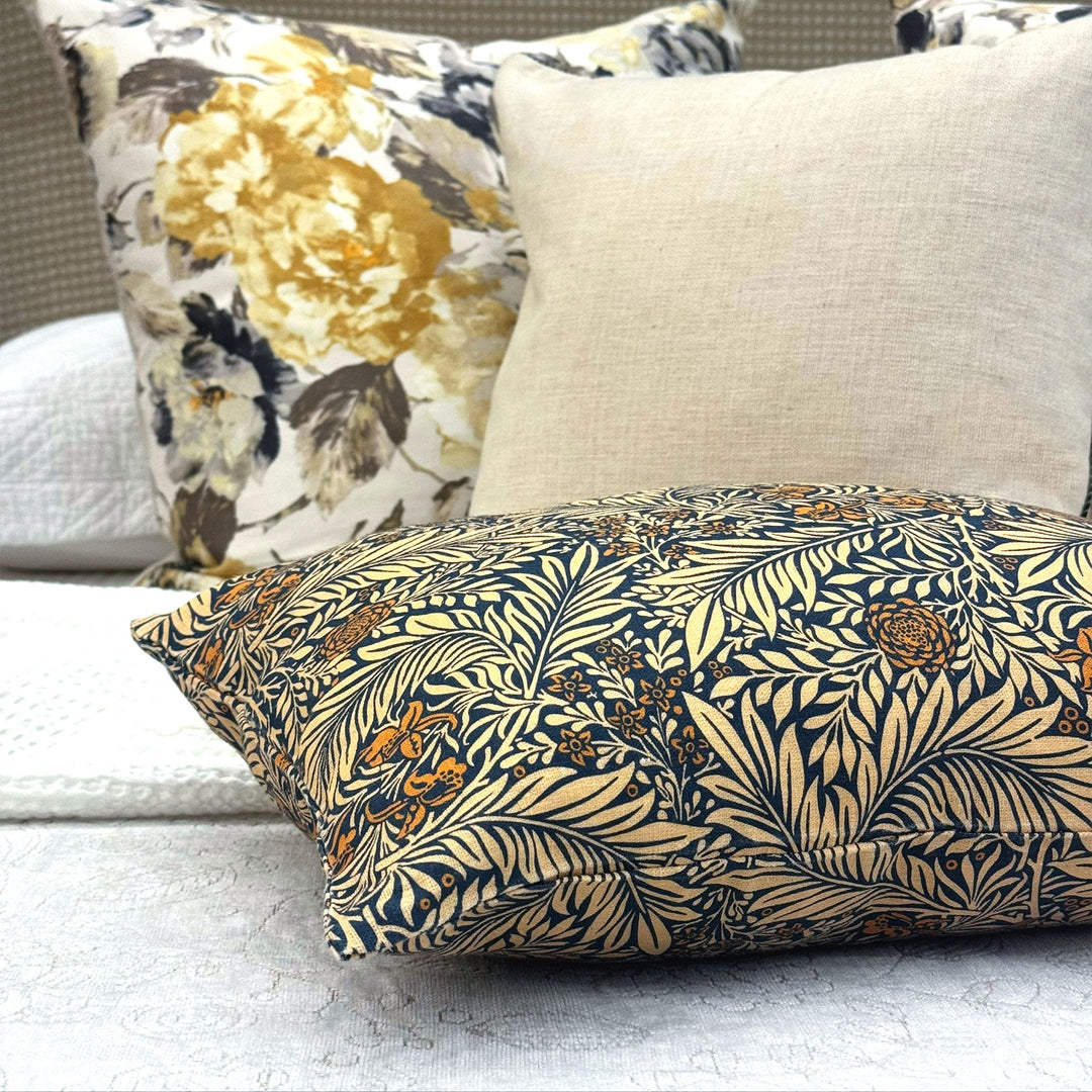 Decorative pillows with floral and leaf patterns on a sofa.