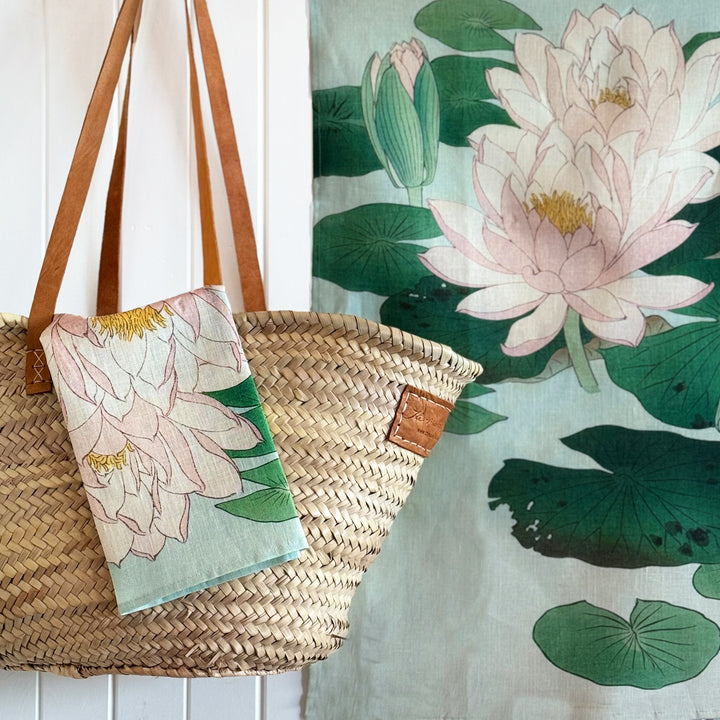Woven bag with floral design next to a painting of water lilies