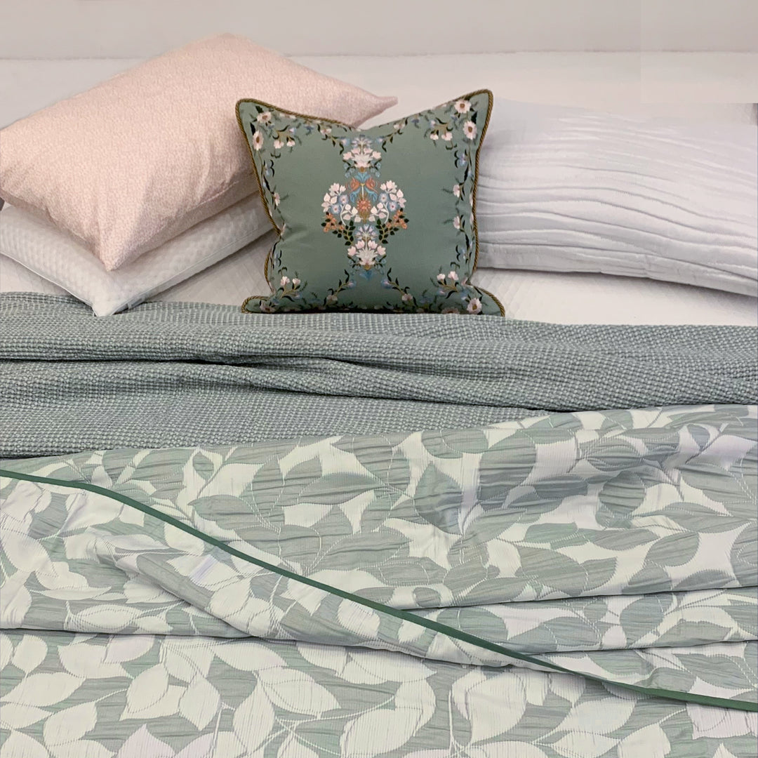 Bed with floral and leaf-patterned bedding and pillows