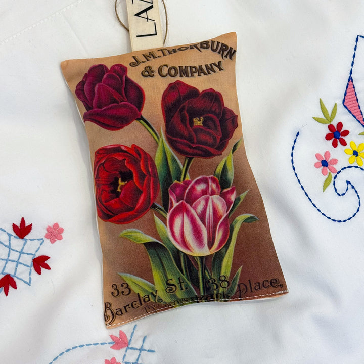 Decorative sachet with floral design and vintage-style text on a white background