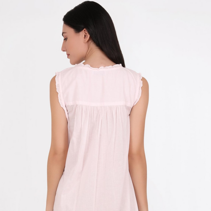 Woman wearing a light pink sleeveless top on a white background