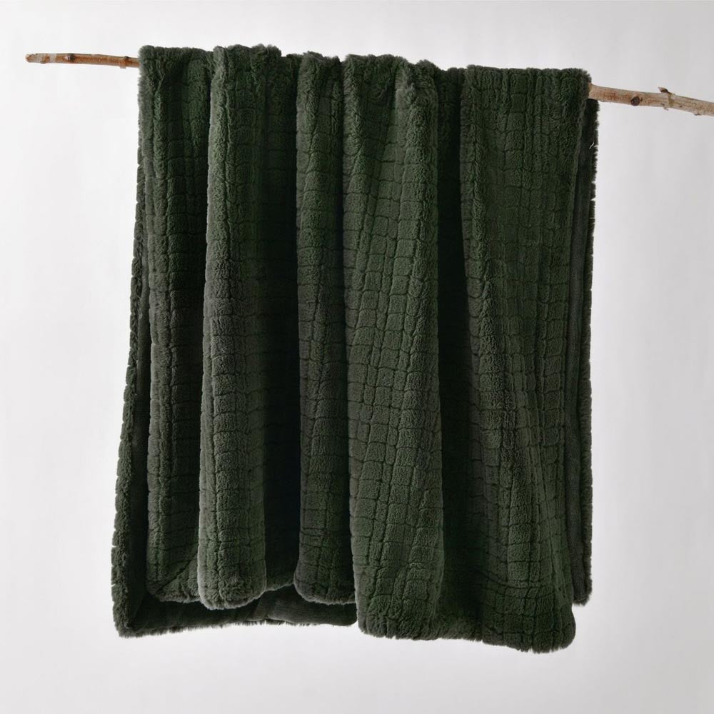 The Bianca Tambar Throw Rug in Forest Green displayed hanging from a rod, revealing its plush faux fur texture and rich colour