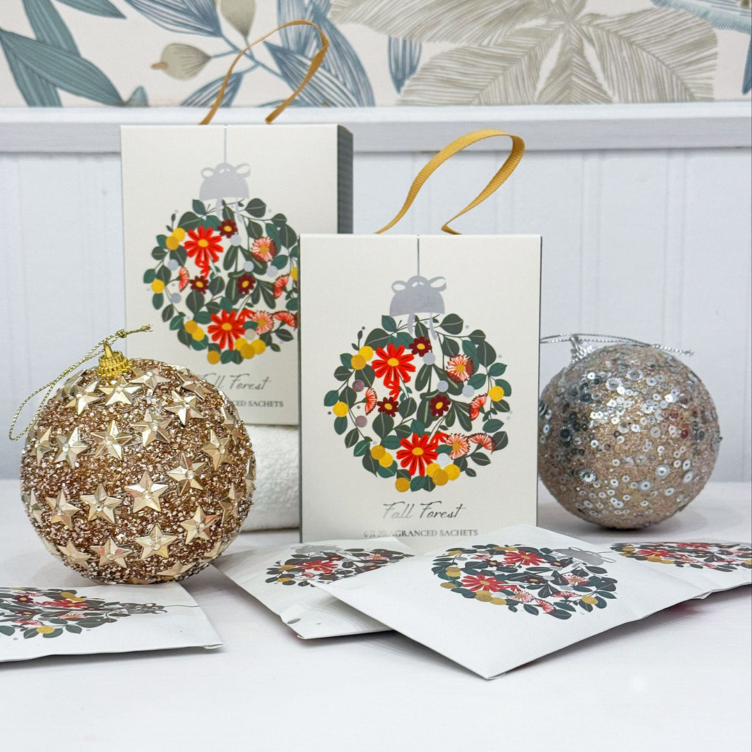 Decorative Christmas balls and cards with floral designs on a white surface.