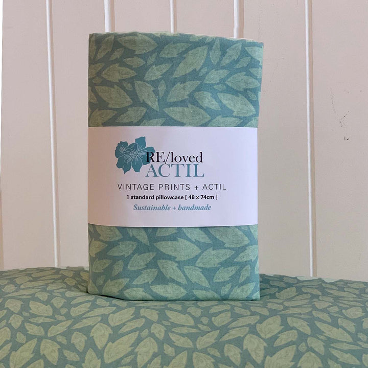 Packaged RE/Loved Actil Hollybush pillowcase with vintage green leaf print and sustainable branding label.
