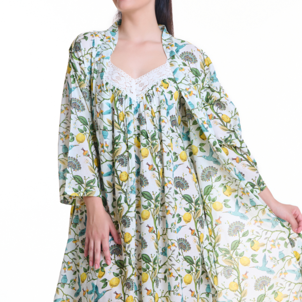 Woman wearing a floral patterned dress with lemons and leaves on a white background