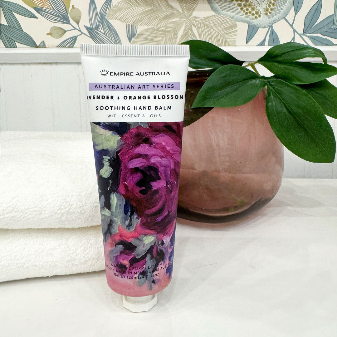Hand balm tube with floral design on a white surface with a decorative background
