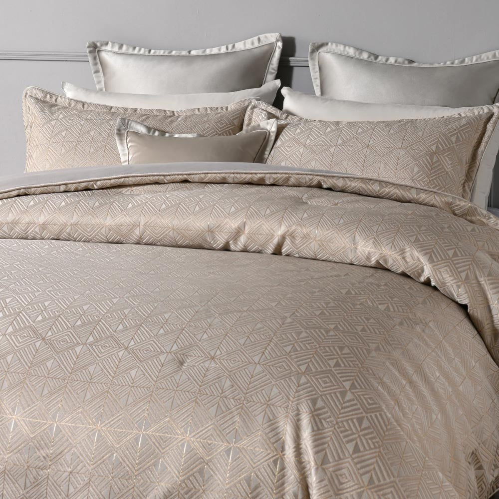 Close-up of the Bianca Bellagio Comforter Set showcasing the detailed geometric jacquard fabric and piped edges in soft gold tones.