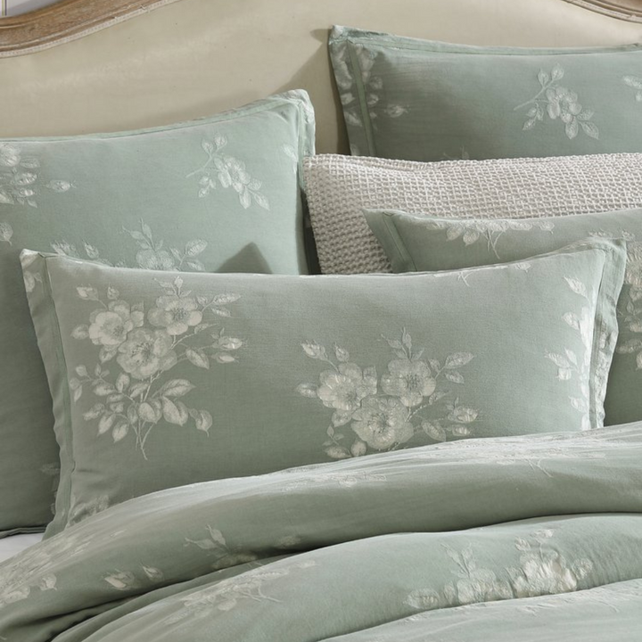 Floral patterned pillows and bedding set on a bed.
