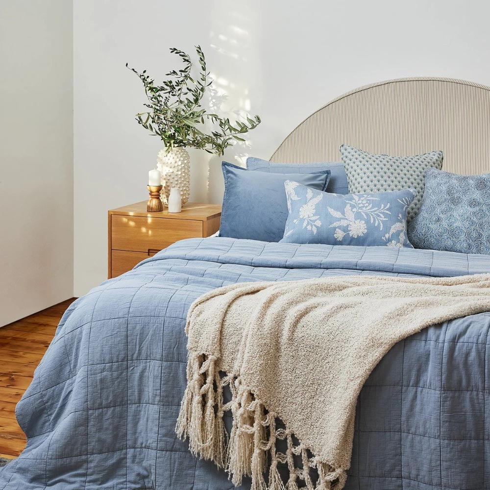 Modern bedroom styled with Bailey Light Blue Coverlet and blue patterned cushions