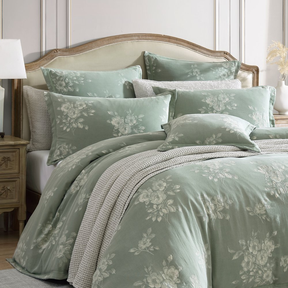Bed with floral bedding and pillows in a bedroom setting
