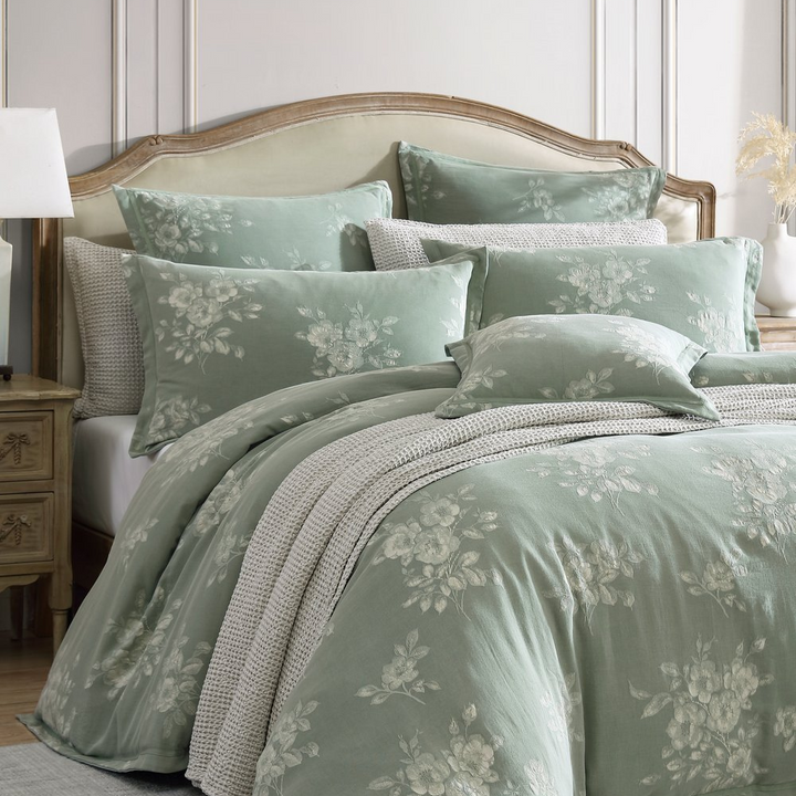 Bed with floral bedding and pillows in a bedroom setting